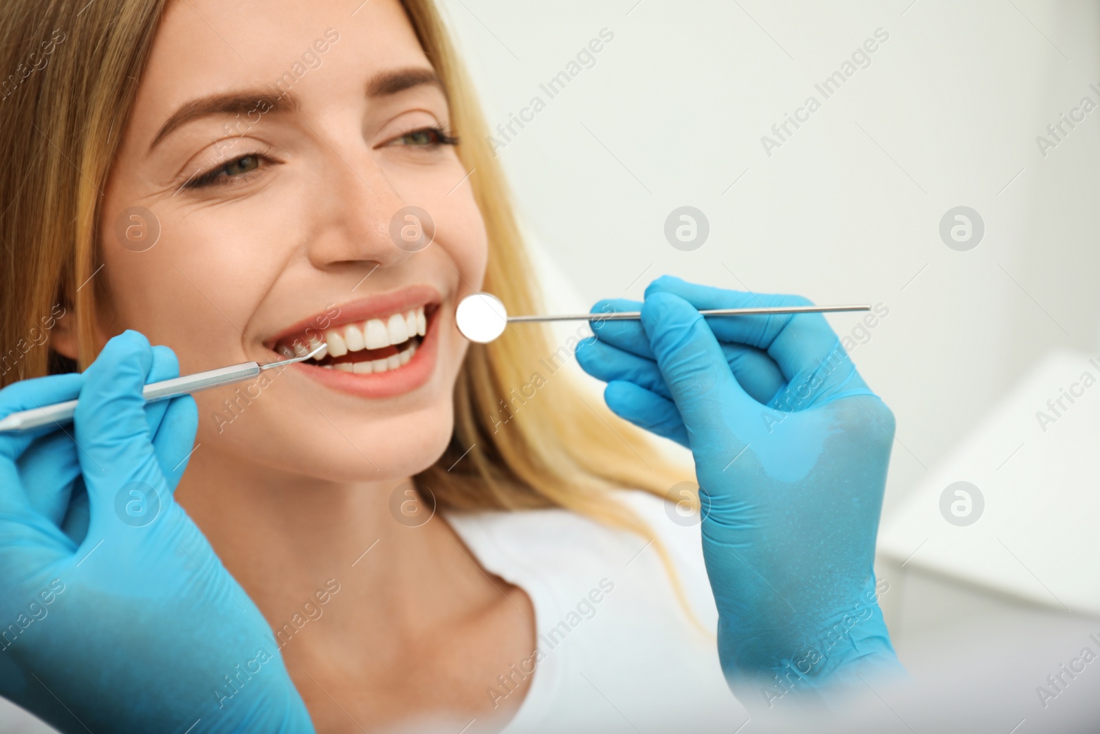 Photo of Doctor examining patient's teeth in clinic, closeup. Cosmetic dentistry