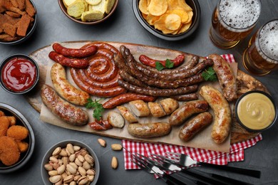 Photo of Set of different tasty snacks and beer on dark grey table, flat lay