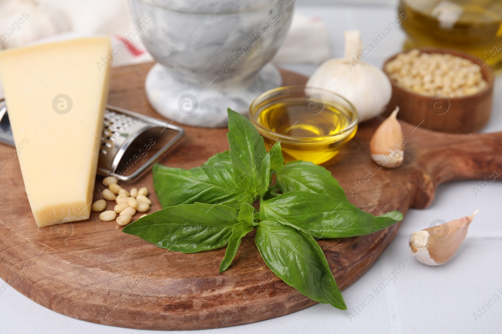 Photo of Different ingredients for cooking tasty pesto sauce on white table, closeup