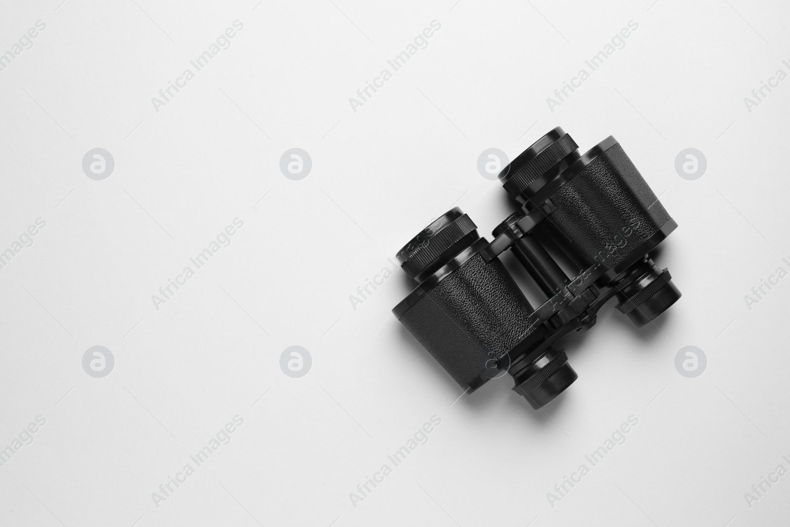 Photo of Modern binoculars on white background, top view. Space for text