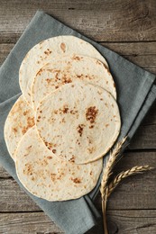 Photo of Tasty homemade tortillas and spikes on wooden table, top view