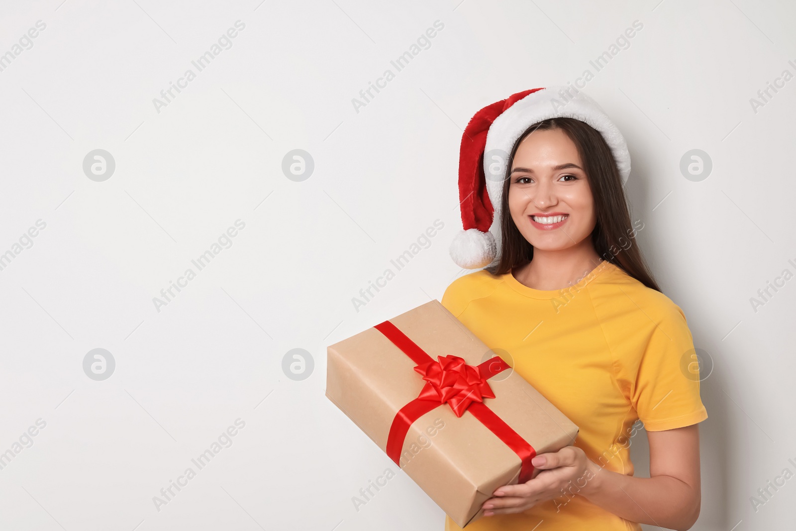 Photo of Young woman with Christmas gift on white background