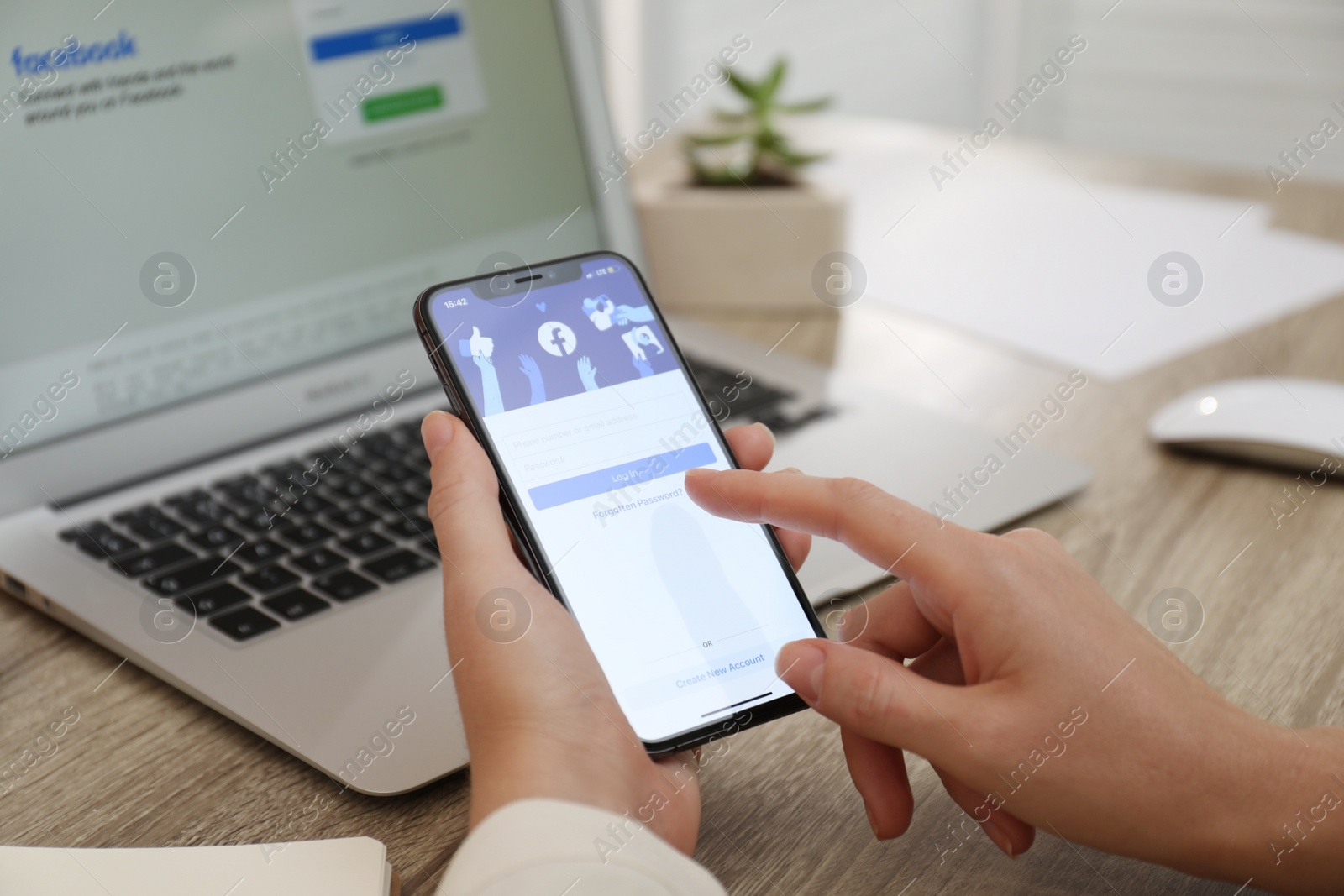 Photo of MYKOLAIV, UKRAINE - AUGUST 28, 2020: Woman holding iPhone 11 with Facebook app on screen at table, closeup