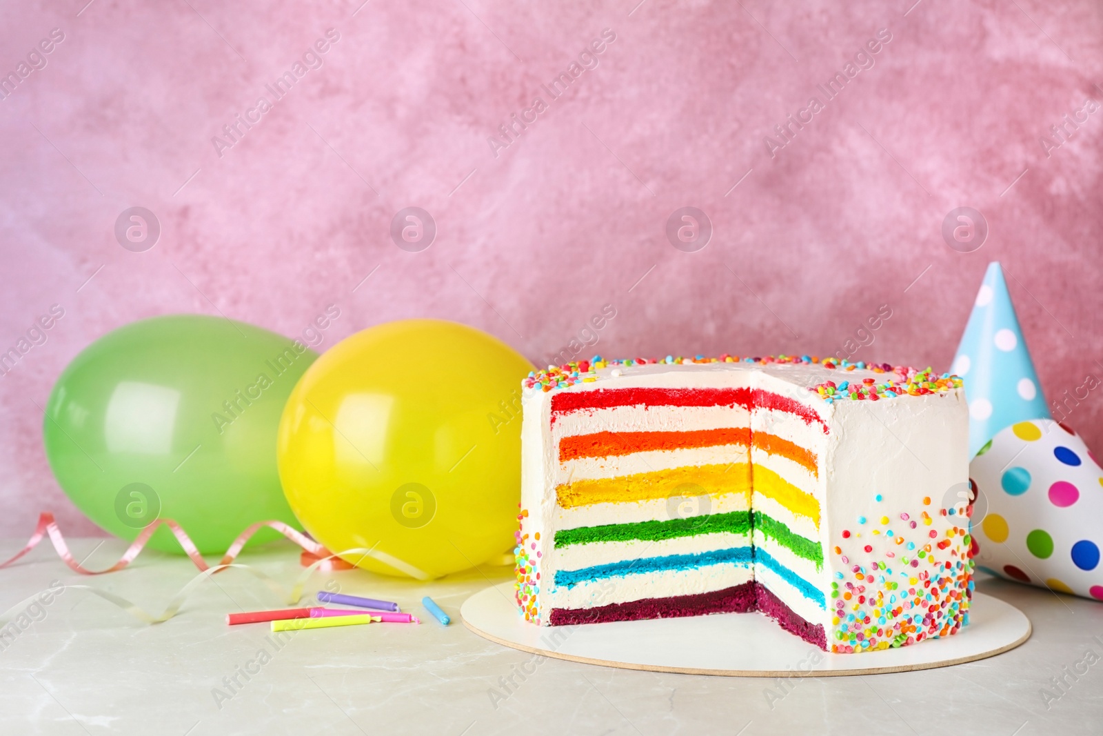 Photo of Delicious rainbow cake for party on table