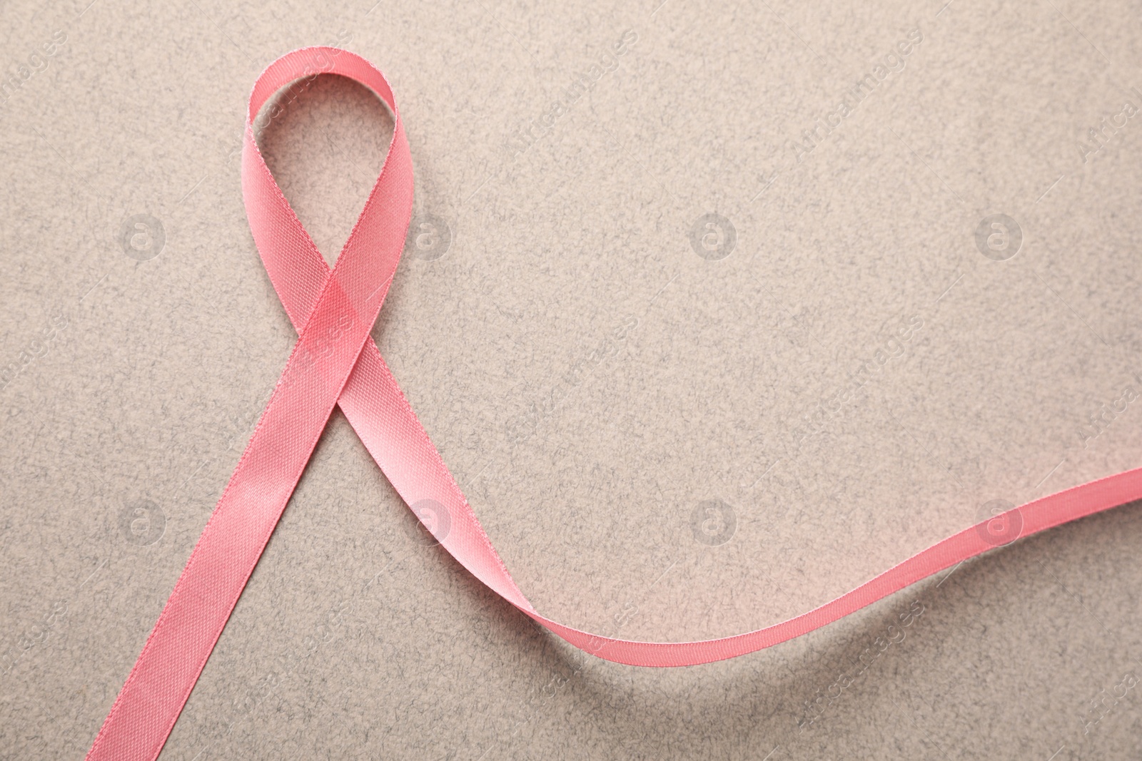 Photo of Pink ribbon on grey background, top view. Breast cancer awareness concept