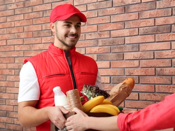 Male courier delivering food to client indoors