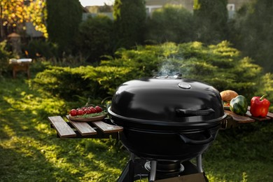 Photo of Closed barbecue grill and different food products outdoors