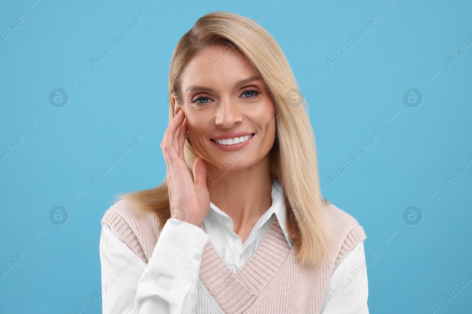 Photo of Portrait of smiling middle aged woman on light blue background