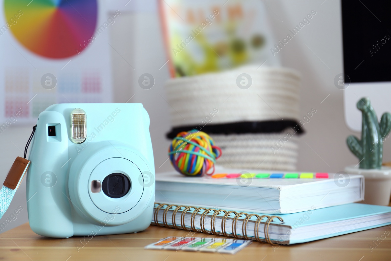 Photo of Digital camera and notebooks on table in studio. Modern designer's workplace