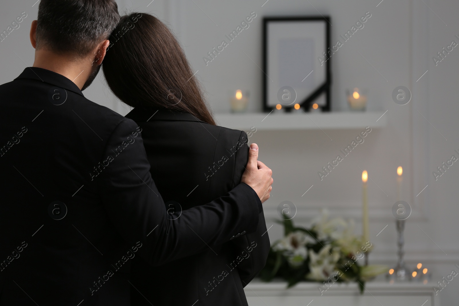 Photo of Couple mourning indoors, back view and space for text. Funeral ceremony