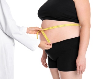 Photo of Doctor measuring fat woman's waist on white background, closeup. Weight loss