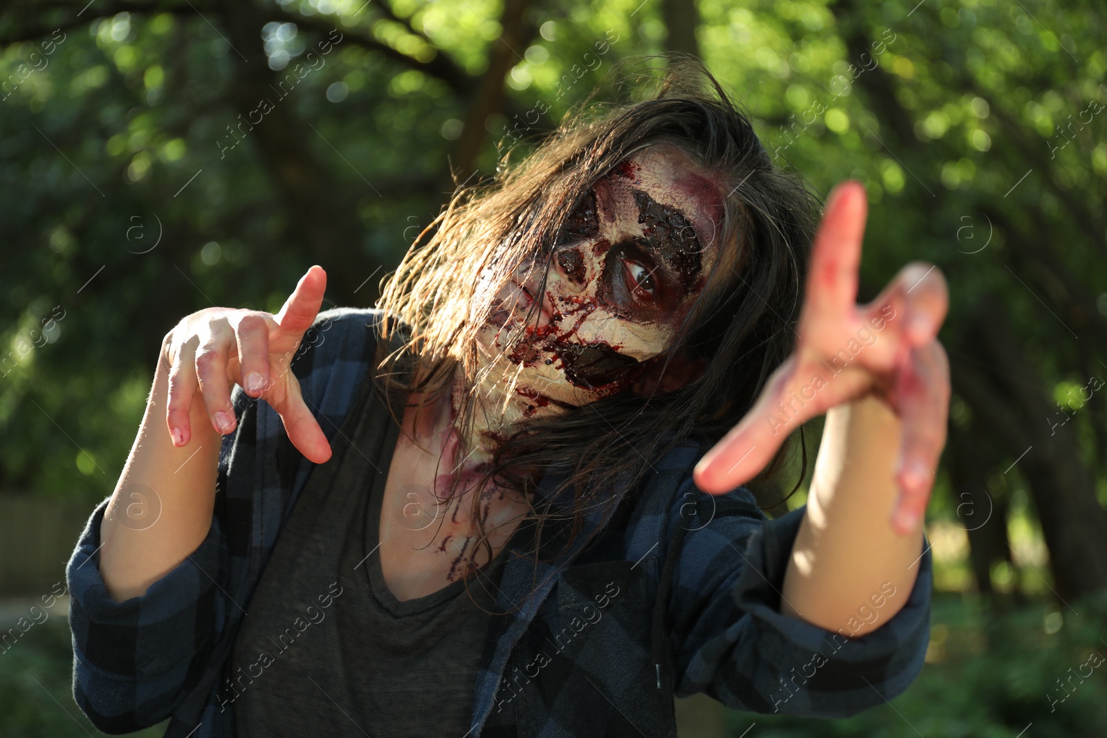 Photo of Scary zombie with bloody face outdoors. Halloween monster