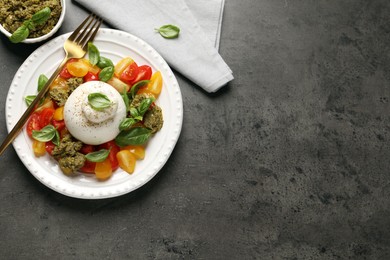 Photo of Delicious burrata salad served on grey table, flat lay. Space for text