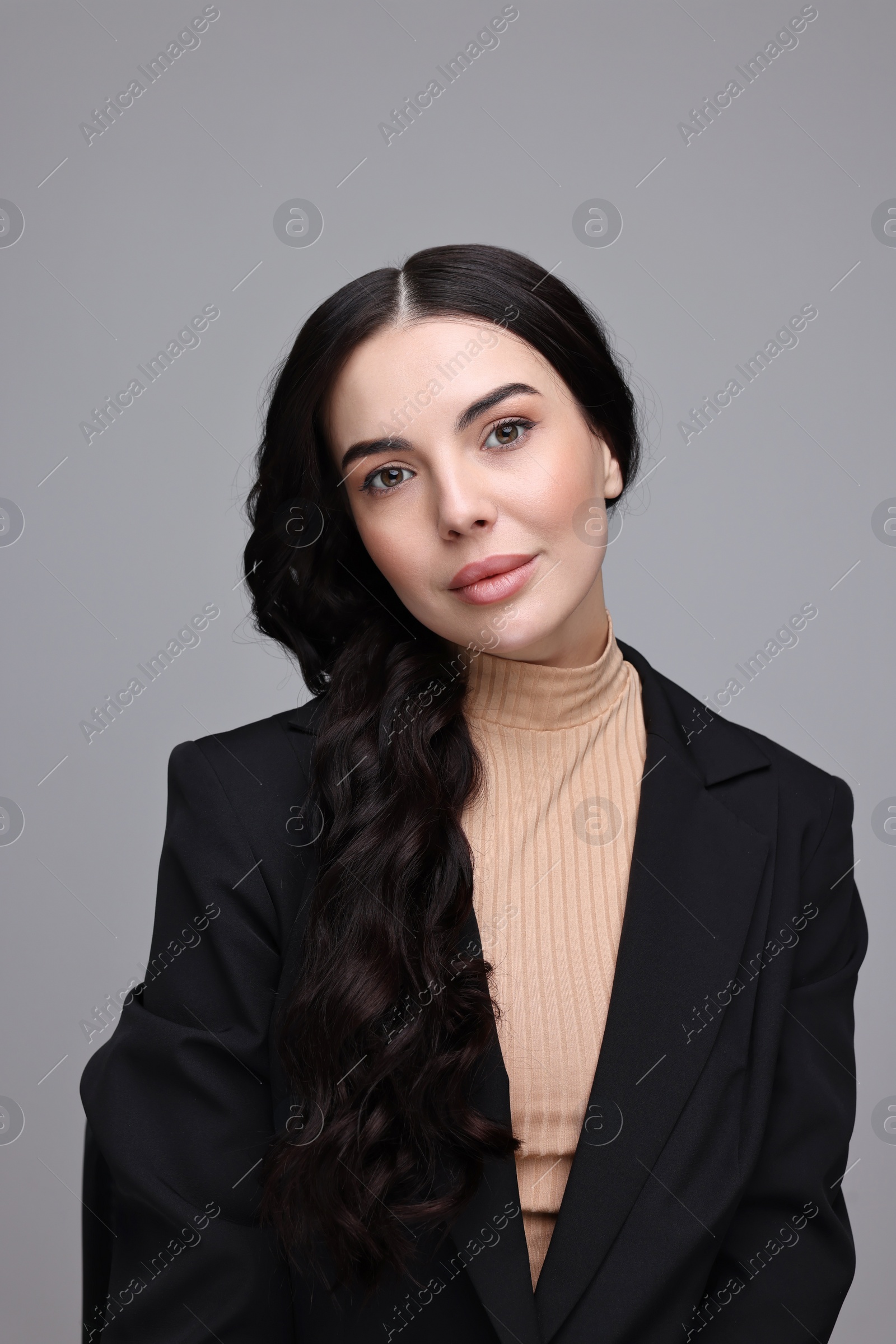 Photo of Beautiful woman in black jacket on gray background