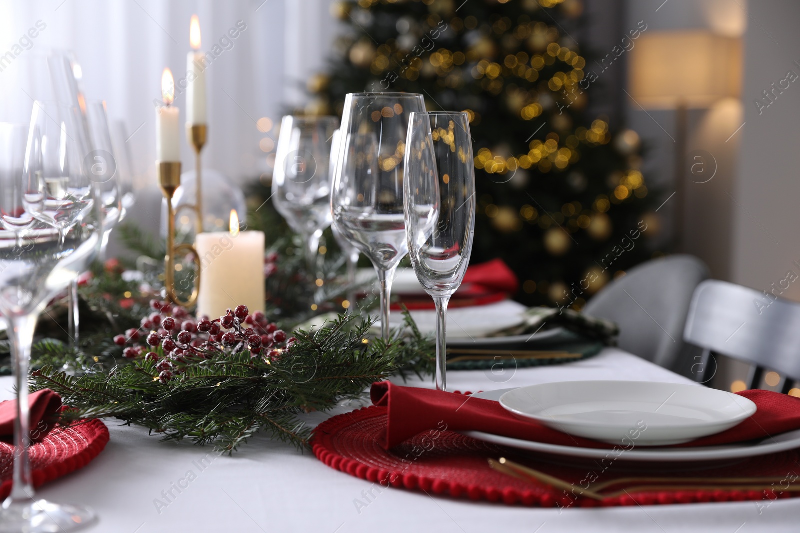 Photo of Christmas table setting with festive decor and dishware indoors