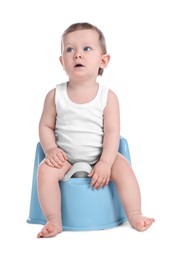 Photo of Little child sitting on baby potty against white background