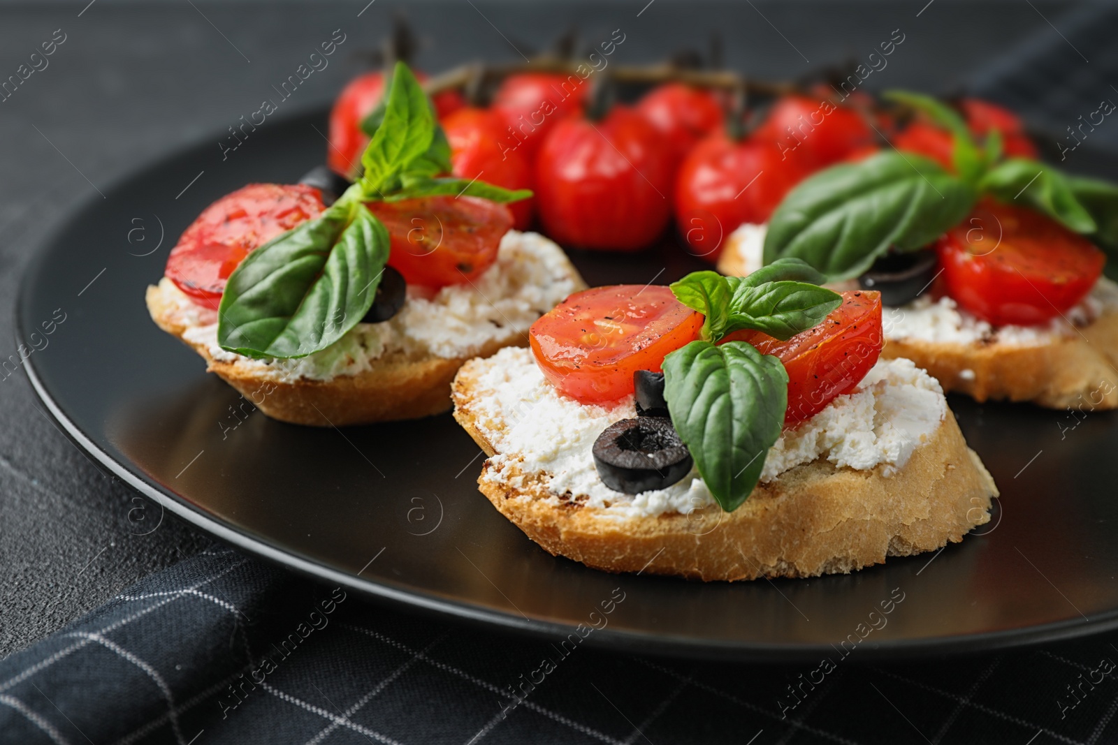 Photo of Plate of delicious tomato bruschettas on table, closeup