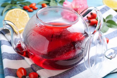 Photo of Fresh rose hip tea and berries on table, closeup