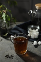 Photo of Tasty hot tea in cup on grey table, closeup