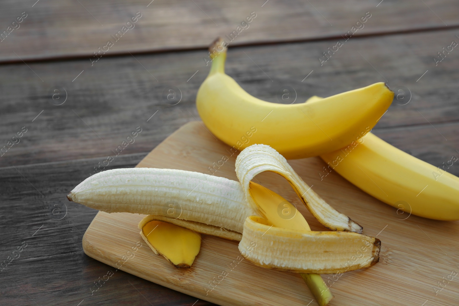 Photo of Delicious yellow bananas on wooden table, closeup