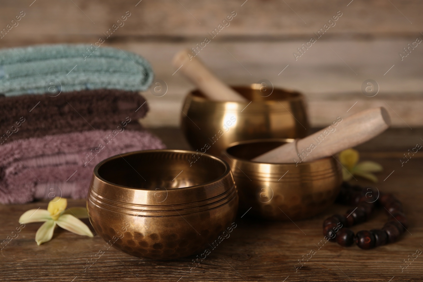 Photo of Composition with golden singing bowls on wooden table