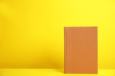 Photo of Hardcover book on yellow background. Space for design