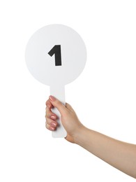 Photo of Woman holding auction paddle with number 1 on white background, closeup