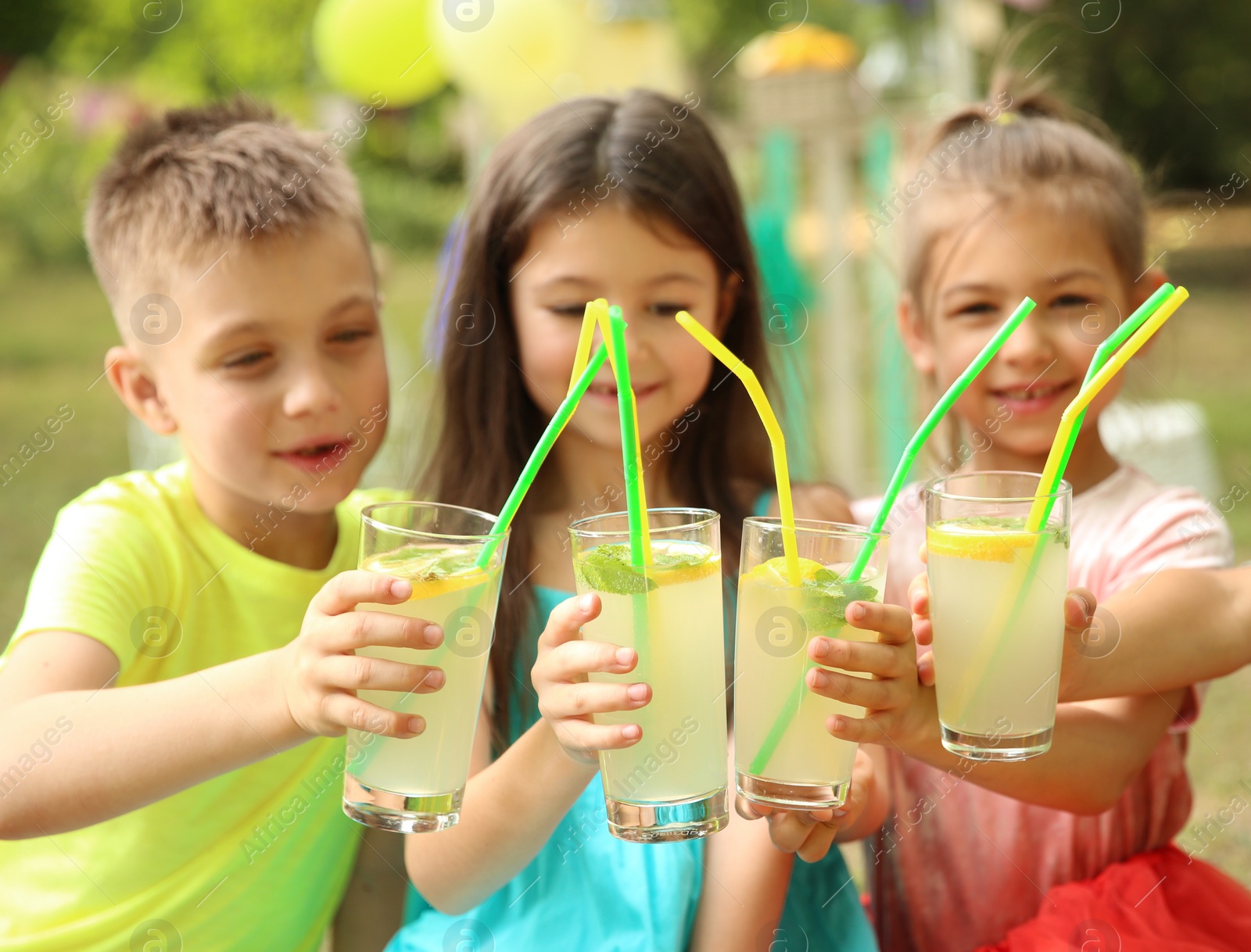 Photo of Little children with natural lemonade in park