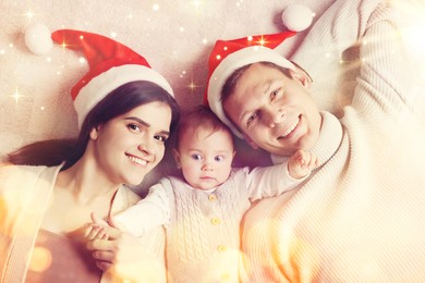 Happy couple with cute baby on floor, top view. Magical Christmas atmosphere