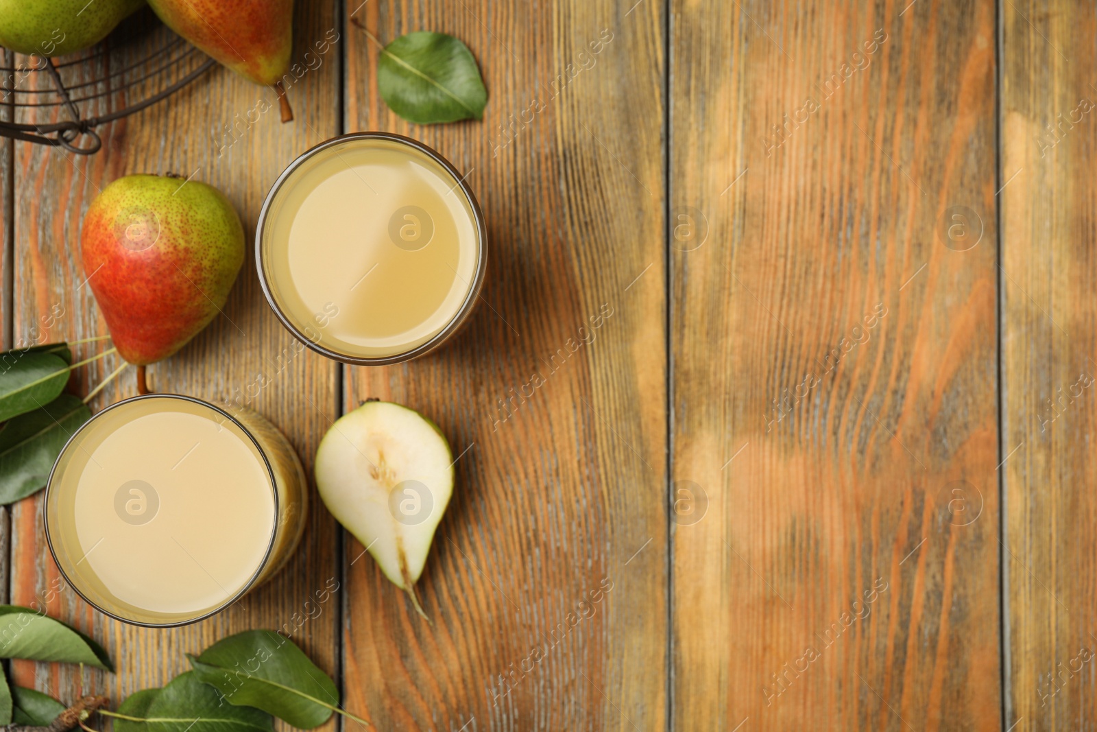 Photo of Tasty pear juice, fruits and leaves on wooden table, flat lay. Space for text