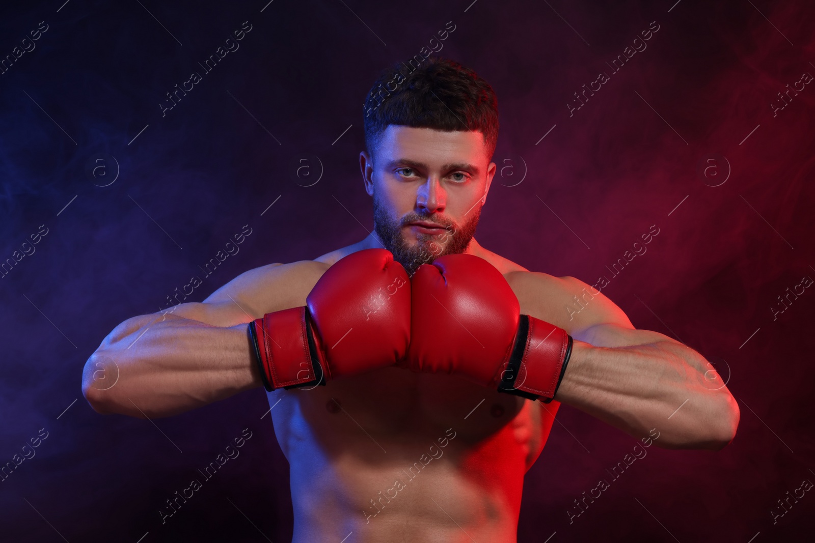 Photo of Man wearing boxing gloves on dark background