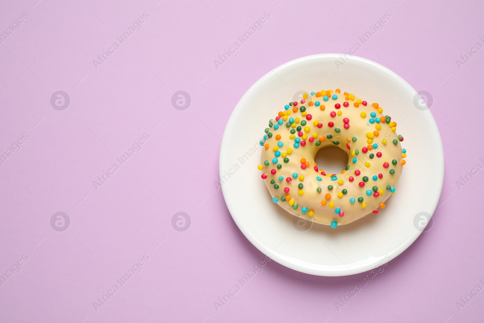 Photo of Delicious glazed donut on lilac background, top view. Space for text