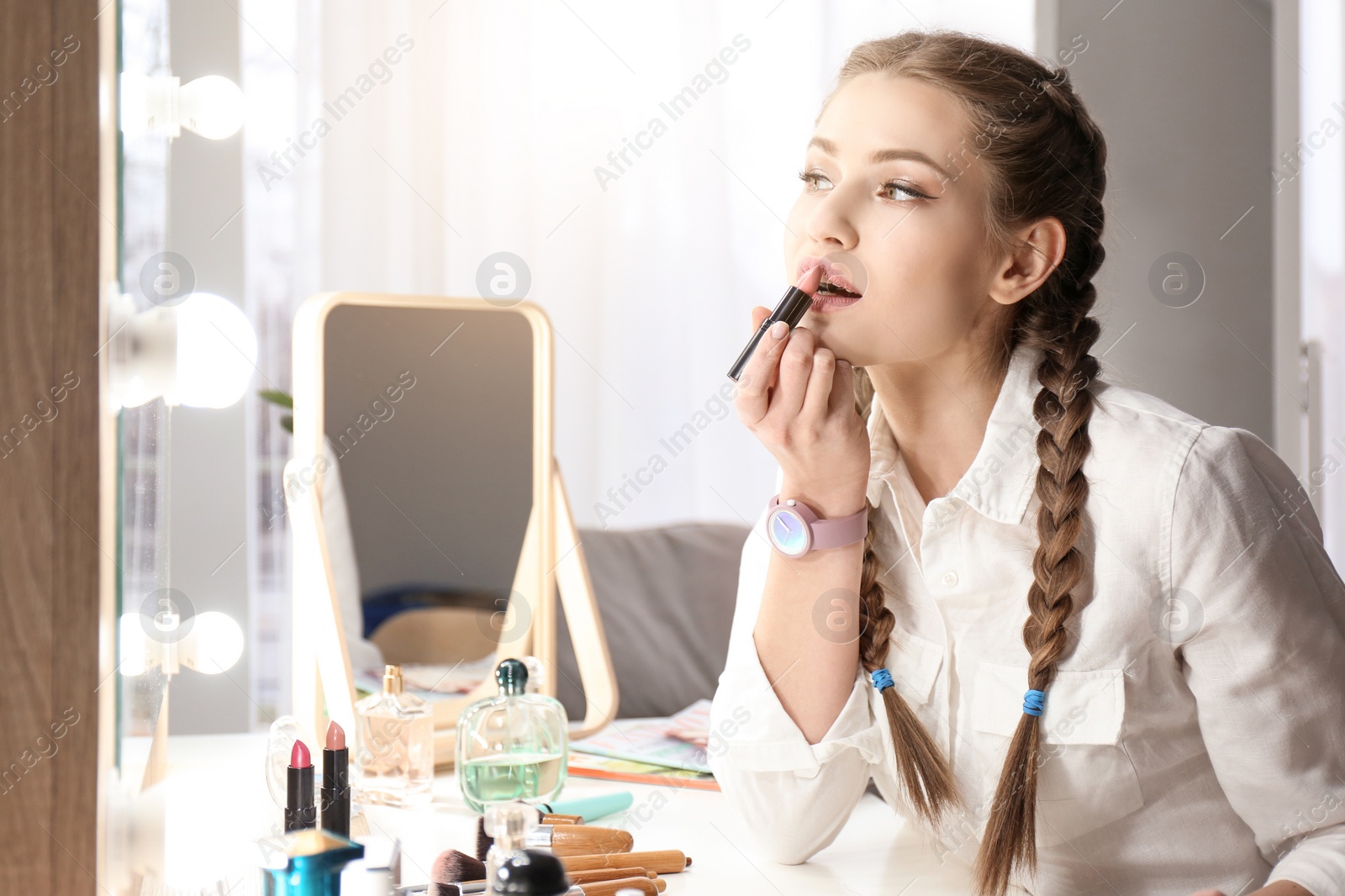 Photo of Portrait of beautiful woman applying makeup indoors