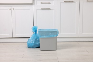 Photo of Plastic garbage bag and trash can in kitchen