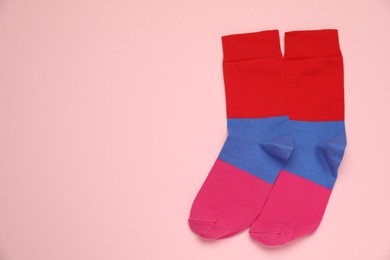 Photo of Striped socks on pink background, flat lay. Space for text
