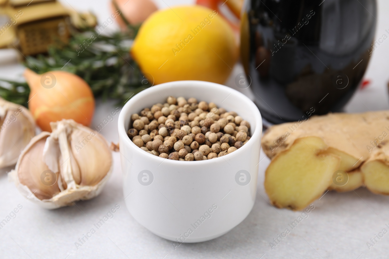 Photo of Aromatic peppercorns and different fresh ingredients for marinade on light grey table