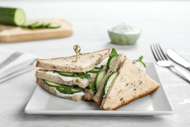 Photo of Plate with tasty cucumber sandwiches served on table