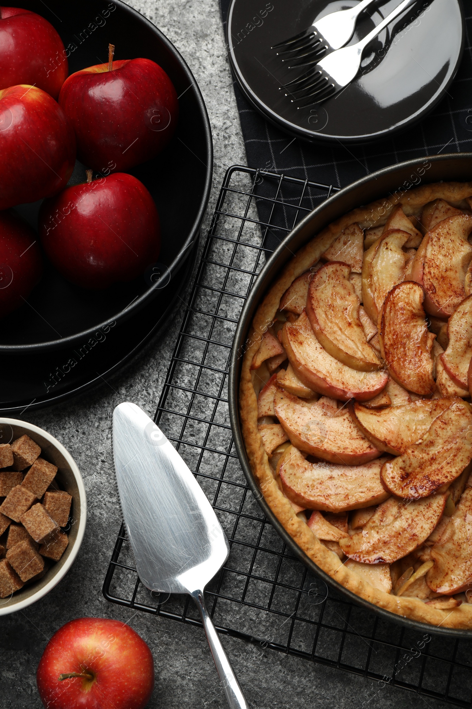 Photo of Delicious apple pie and ingredients on grey table, flat lay