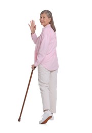Photo of Senior woman with walking cane waving on white background
