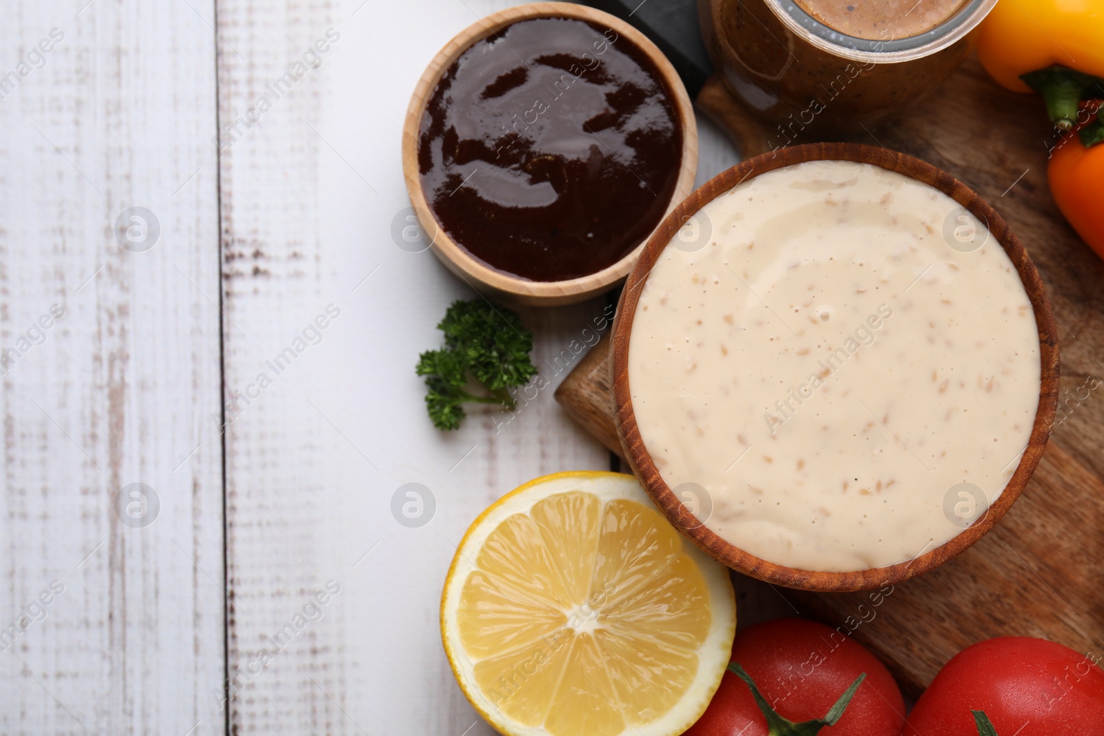 Photo of Different fresh marinades and ingredients on white wooden table, flat lay. Space for text