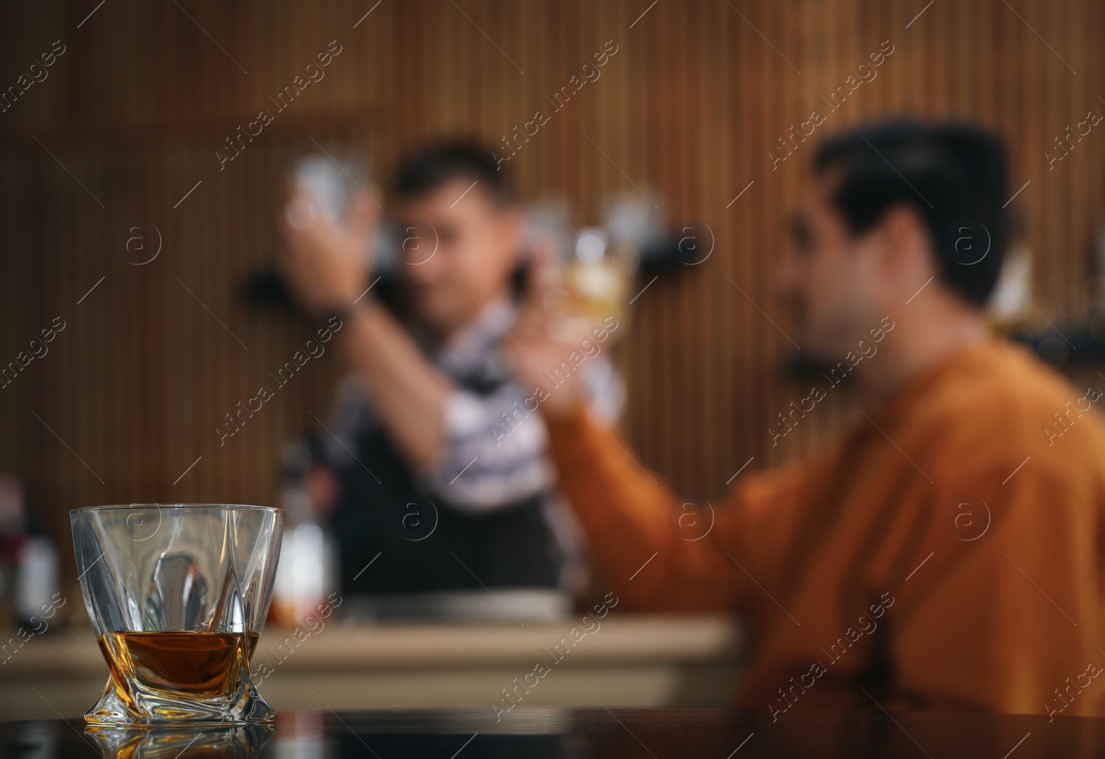 Photo of Glass of whiskey on table in bar. Space for text