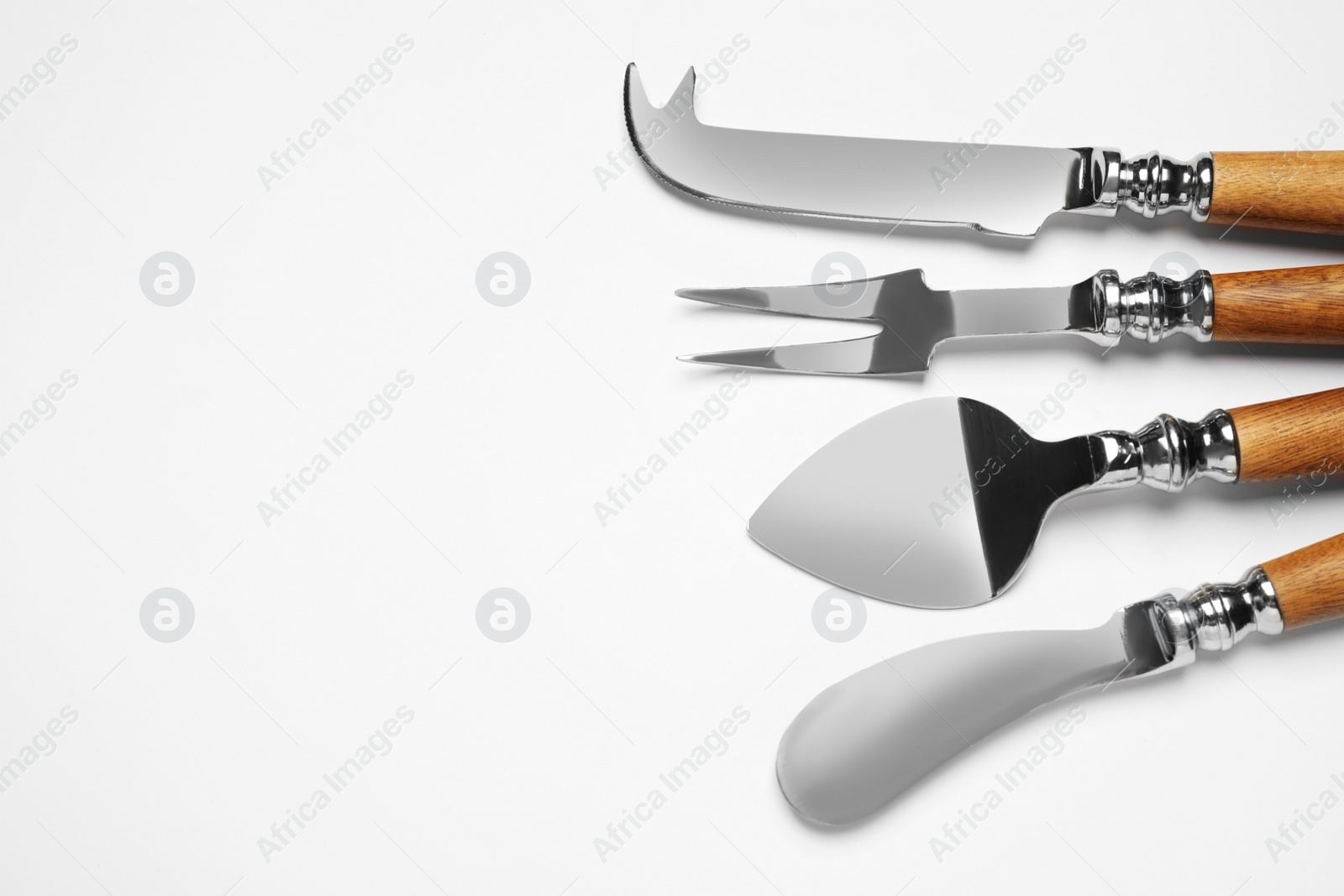 Photo of Cheese knives and fork on white background, top view