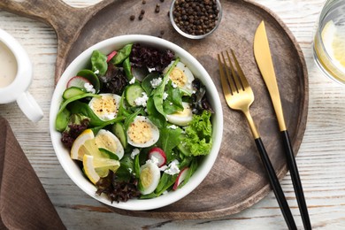 Photo of Delicious salad with boiled eggs, vegetables and lemon served on white wooden table, flat lay