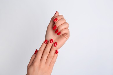 Photo of Woman with red polish on nails against white background, closeup