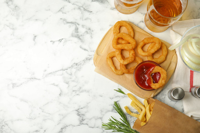 Fried onion rings served on white marble table, flat lay. Space for text