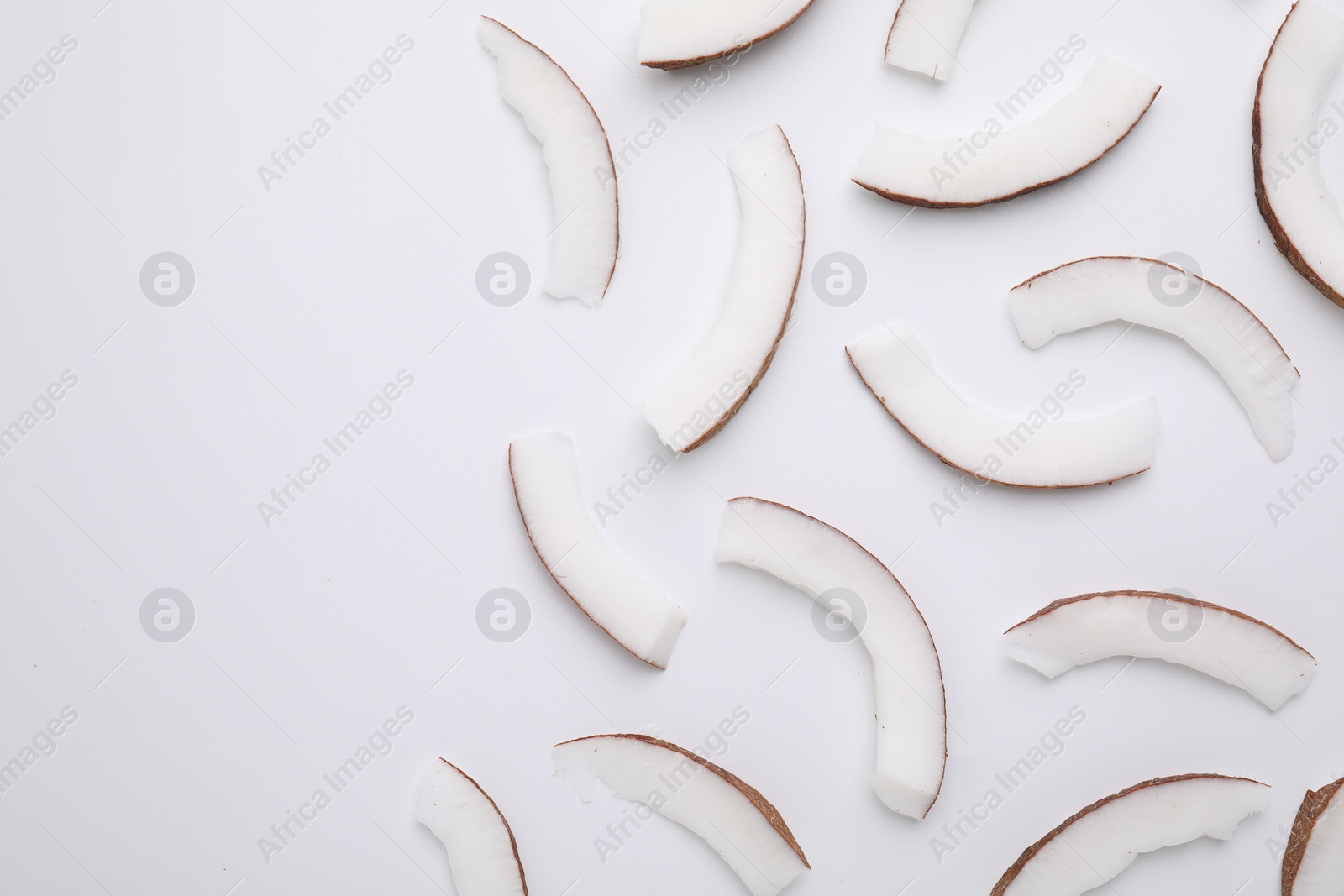 Photo of Pieces of fresh coconut on white background, top view. Space for text