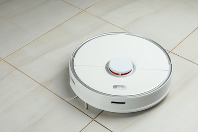 Photo of Robotic vacuum cleaner on white tiled floor