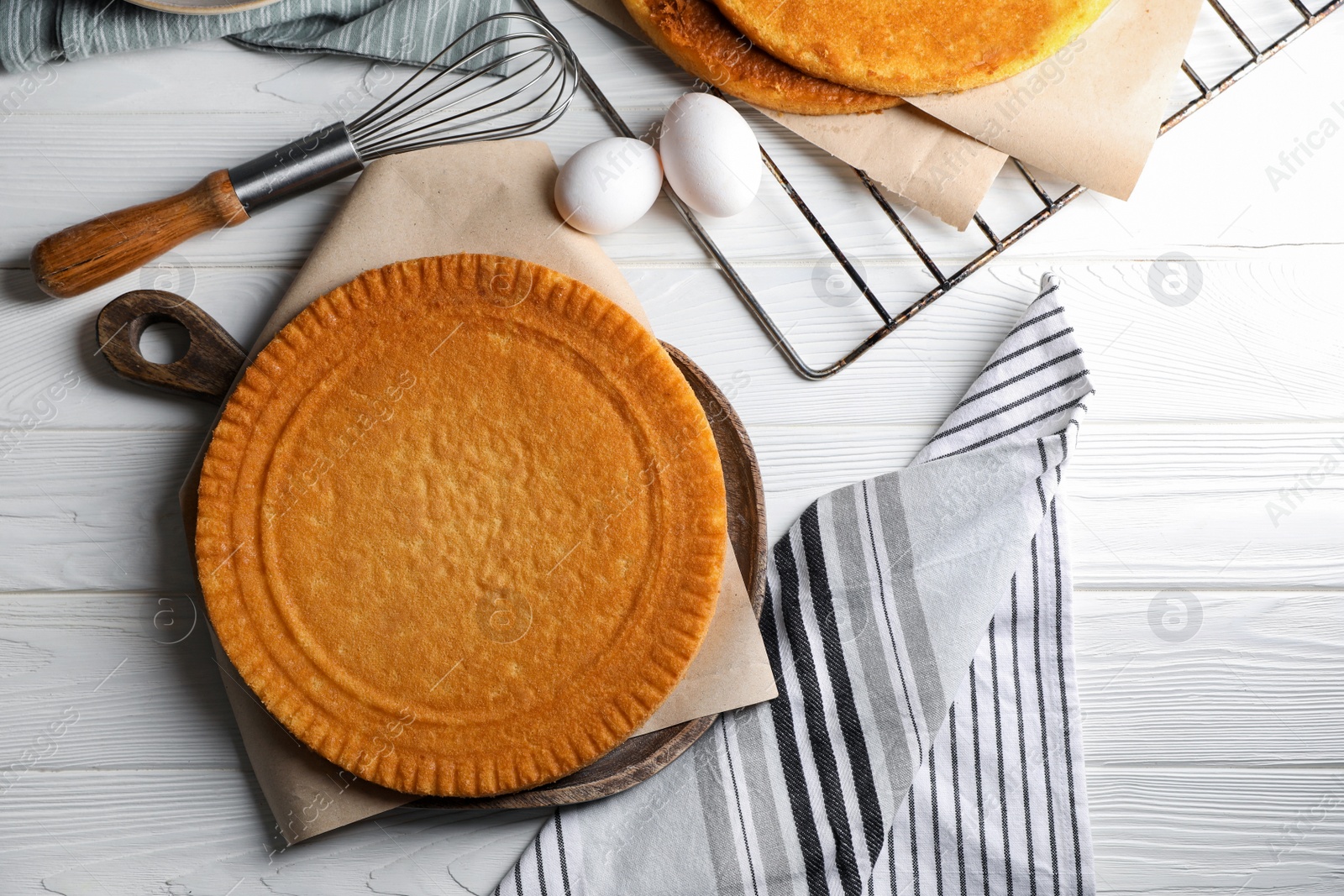 Photo of Ingredients for delicious homemade layer cake preparing on white wooden table, flat lay