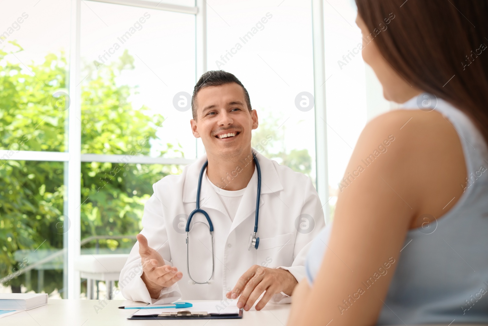 Photo of Young doctor speaking to patient in hospital