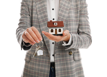 Photo of Real estate agent holding house model and key on white background, closeup